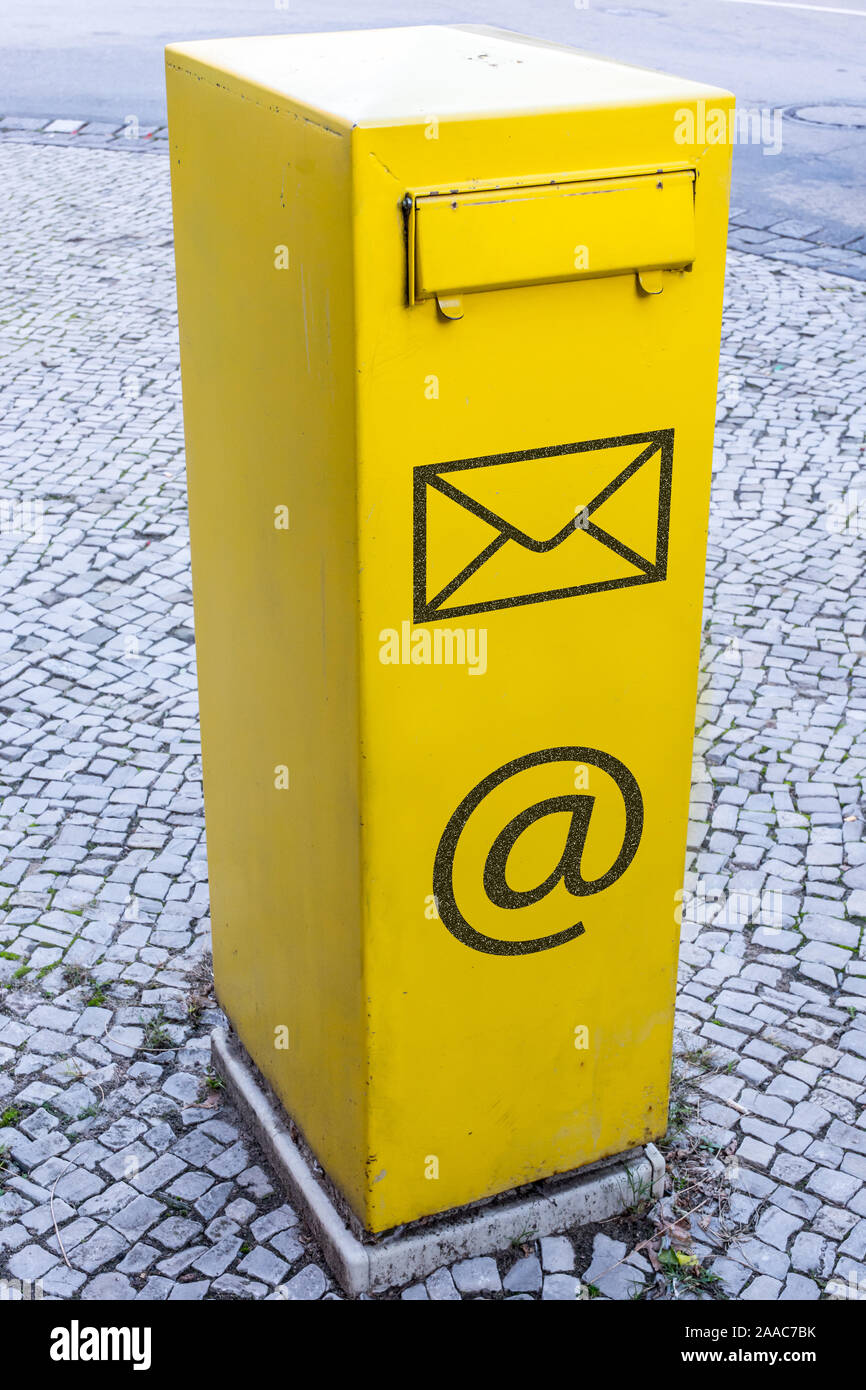Cassetta postale di giallo con il simbolo a lettera e e-mail simbolo come un segno di comunicazione Foto Stock