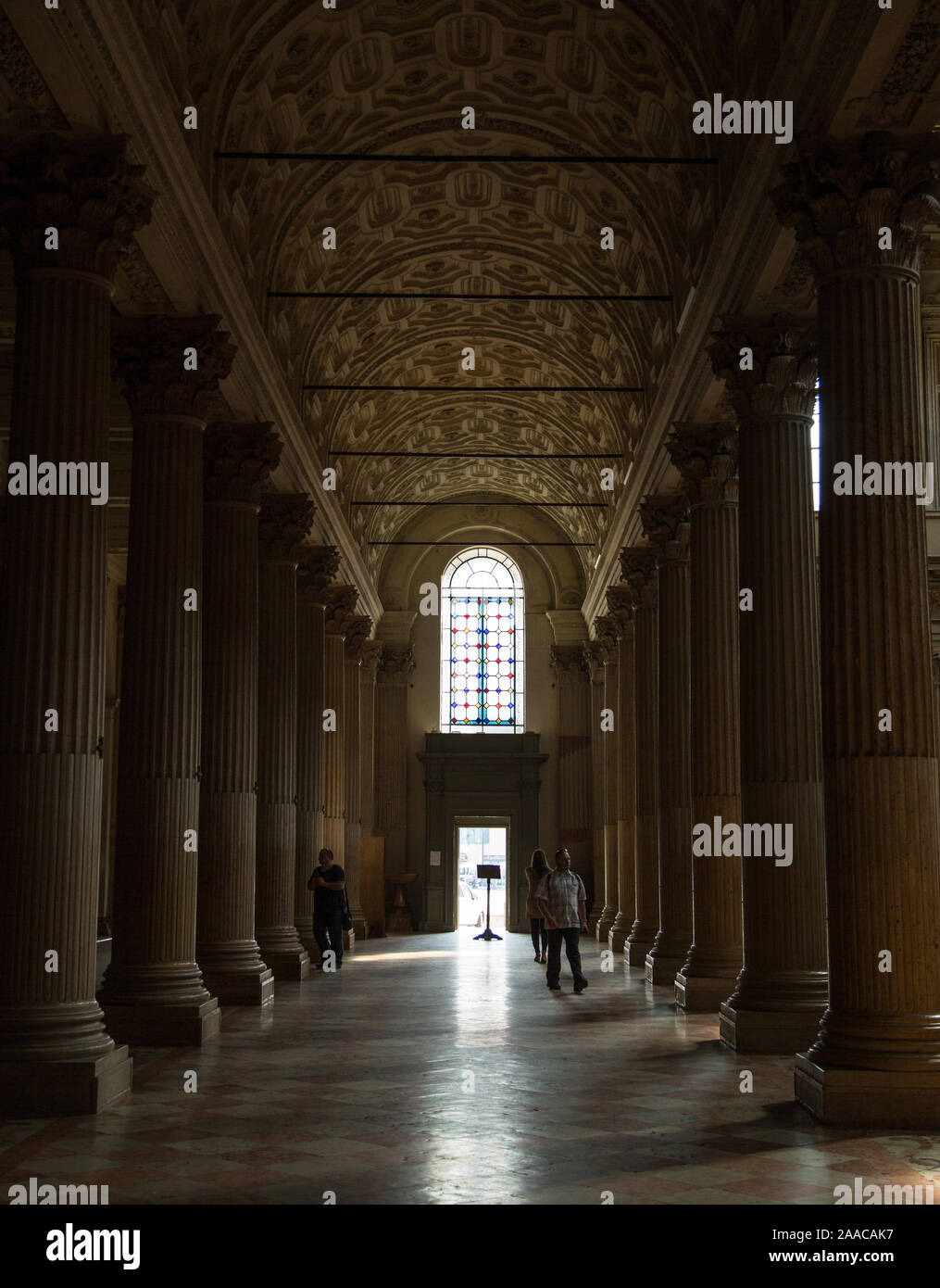 Una sala buia del Duomo di Mantova con una luce alla fine, fiancheggiata da colonne. A Mantova (Mantova), Italia. Foto Stock