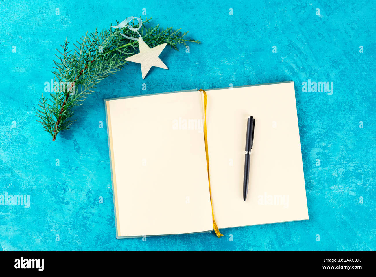 Risoluzioni del nuovo anno o benna elenco concetto, un laico flat top shot di un ufficiale su uno sfondo turchese con una penna, un albero di Natale ramo Foto Stock