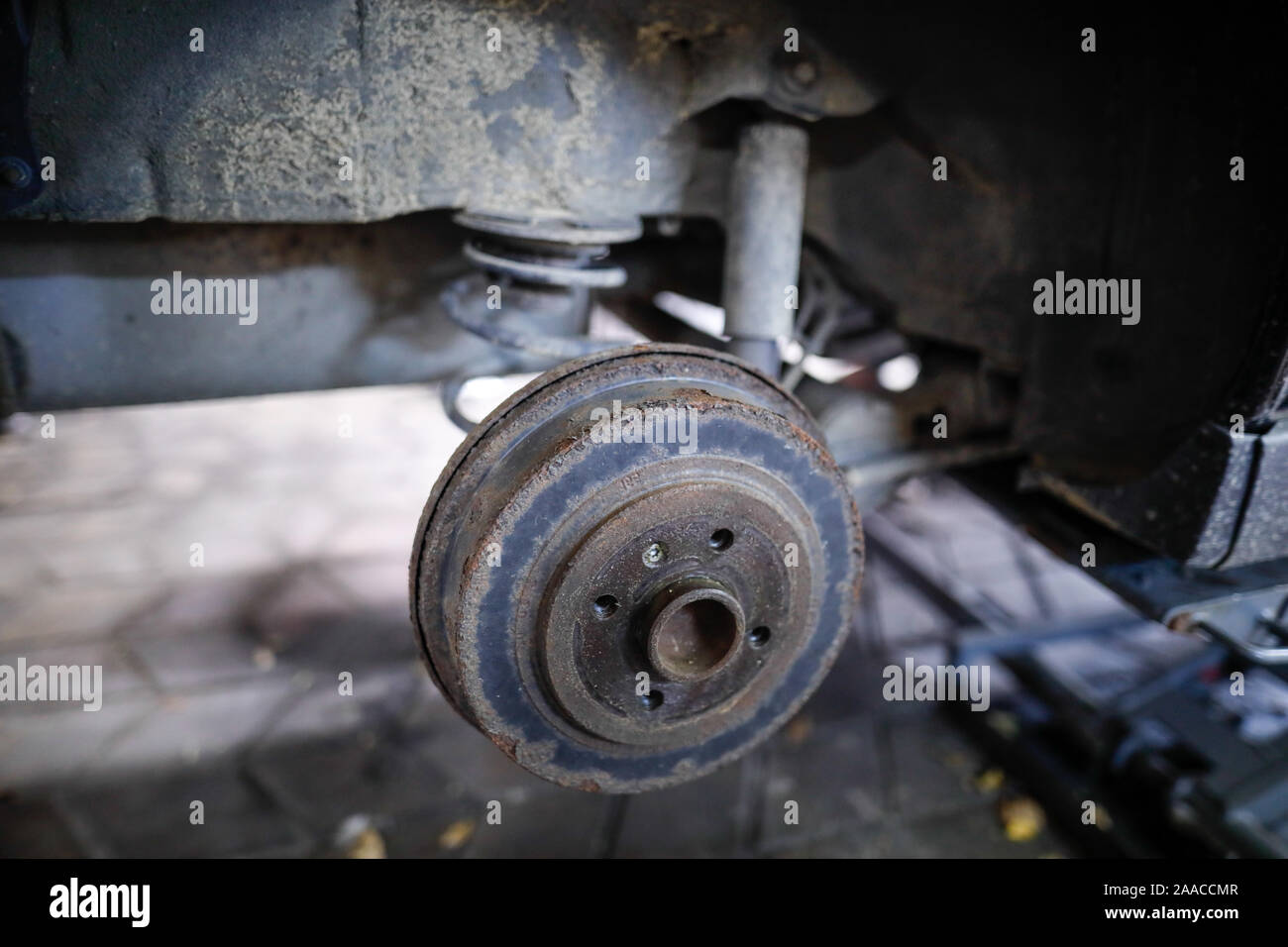 Profondità di campo (messa a fuoco selettiva) immagine con un arrugginito mozzo di ruota posteriore di una vecchia auto. Foto Stock