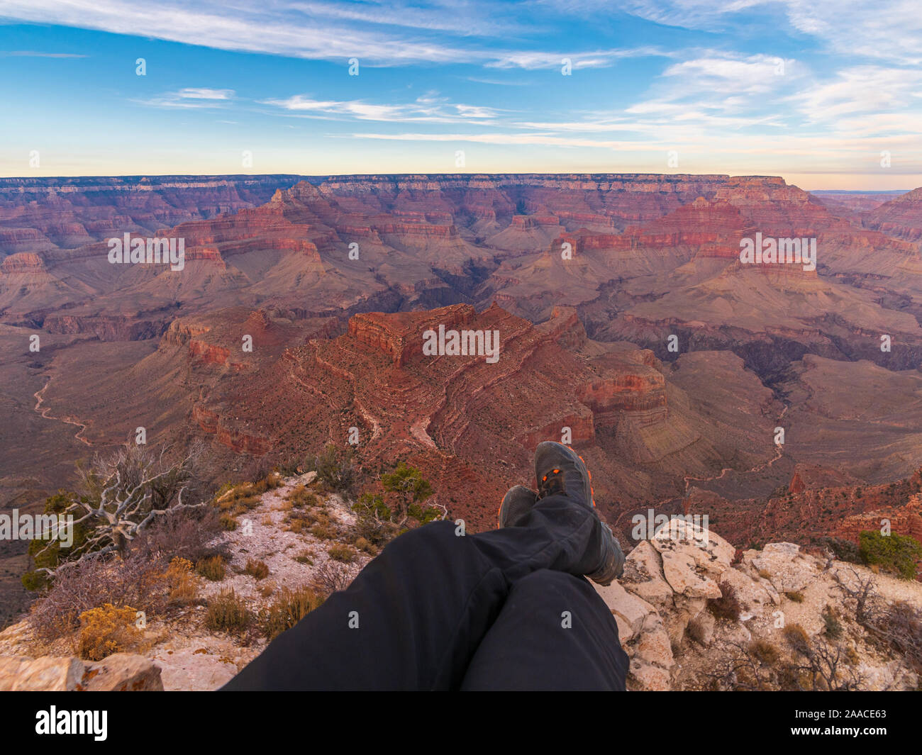 Foto di gambe in scarpe da trekking sullo sfondo del Grand Canyon Foto Stock