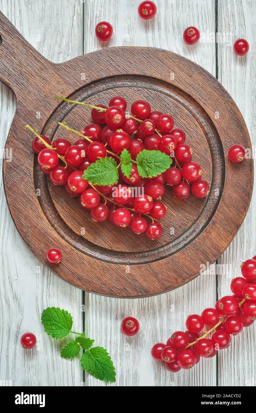 Frutta rossa in cucina. Ribes rosso su bianco un tavolo di legno. Foto Stock