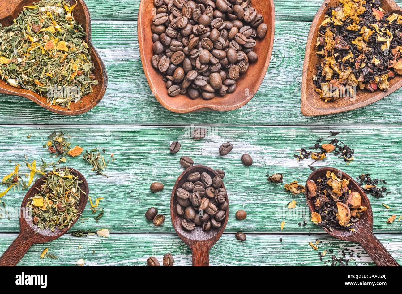 Concetto interessante con una selezione di bevande. Chicchi di caffè, tè di frutta e di erbe su un tavolo di legno. Foto Stock