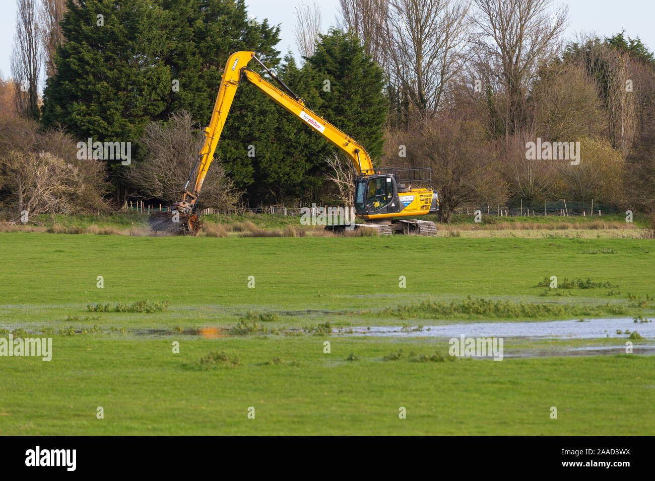 Il dragaggio con una gru di JCB, la cancellazione delle vie navigabili, segala, east sussex, Regno Unito Foto Stock