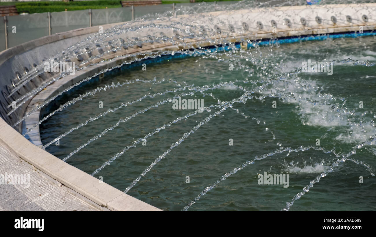 Singolare fontana di moderno design. Flussi di acqua a cascata verso il basso la ceramica blu gradini nella Fontana nel parco della città. Outdoor intrattenimento gratuito per le persone. Foto Stock