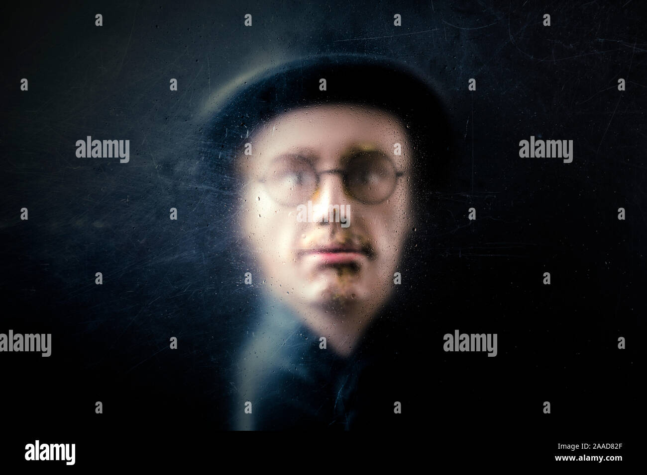 Mistero figura dietro un polveroso vetro graffiato Foto Stock