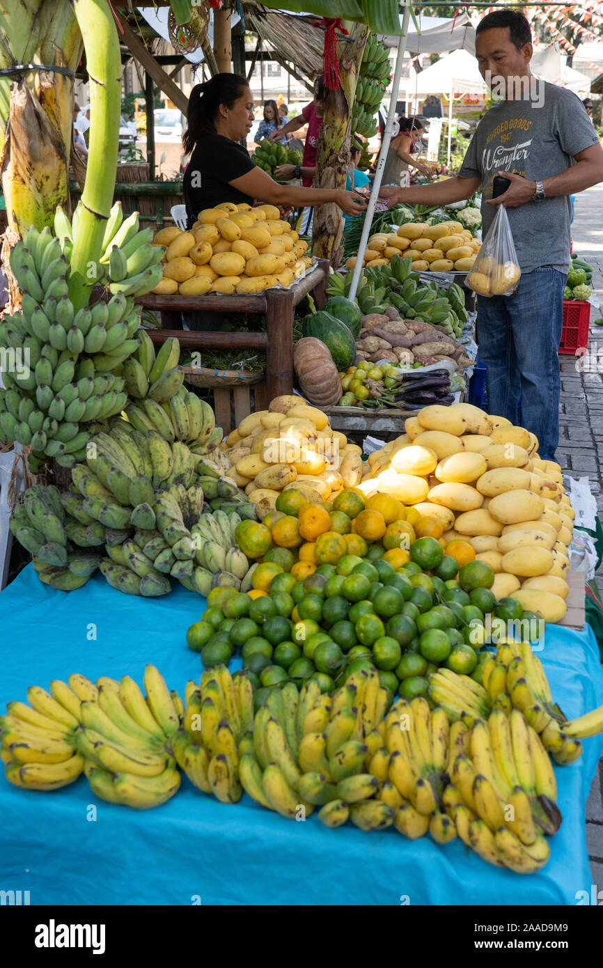 Un uomo acquisto di frutta fresca da uno stallo entro un mercato degli agricoltori,Cebu City, Filippine Foto Stock
