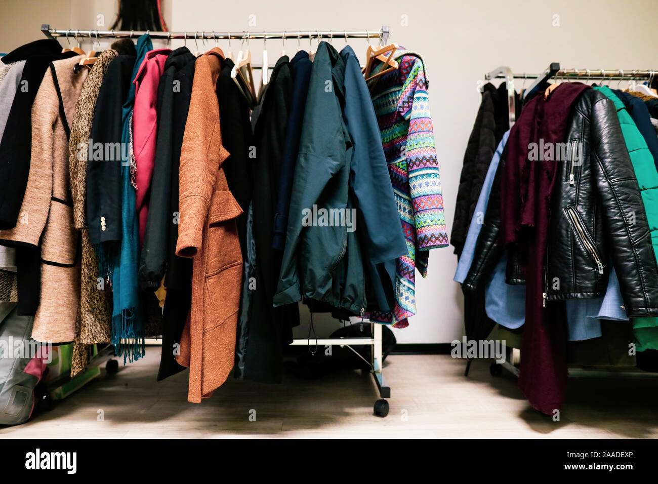 Le donne e gli uomini nel tardo autunno o inverno abiti su un metallo appendiabiti stand. Foto Stock