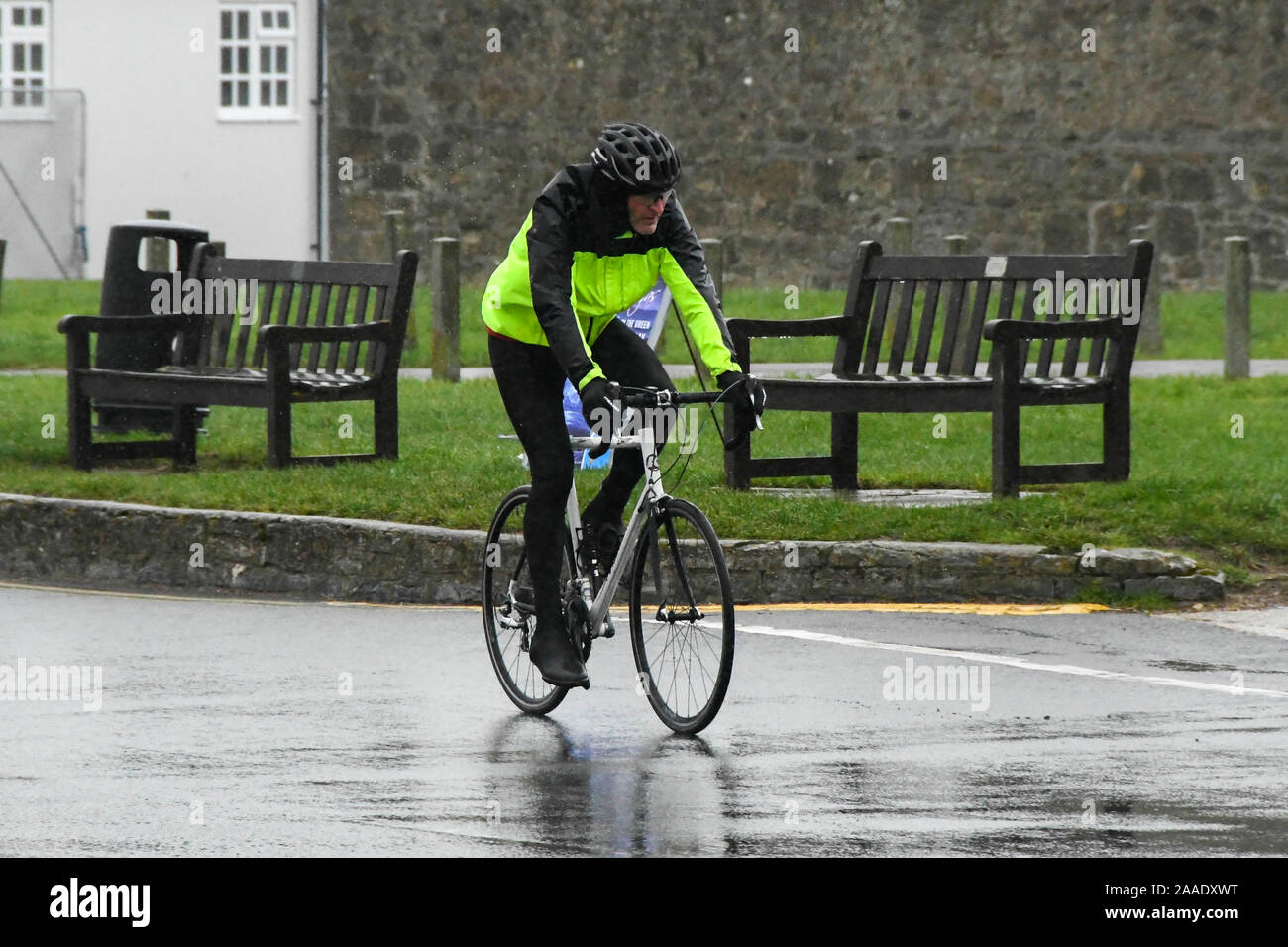 West Bay, Dorset, Regno Unito. Il 21 novembre 2019. Regno Unito Meteo. Un ciclista che indossa impermeabilizza equitazione in heavy rain a West Bay nel Dorset. Credito Foto: Graham Hunt/Alamy Live News Foto Stock