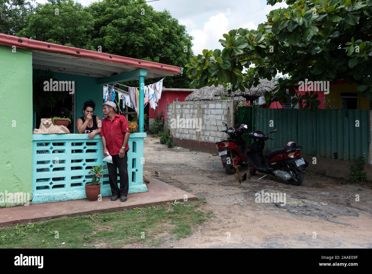 Una donna cubana e il suo vicino che hanno tempo per un pettegolezzo a casa sua in una fattoria di tabacco nella Valle de Vinales, nella provincia di Pinar del Río, a ovest di Cuba. Cub Foto Stock