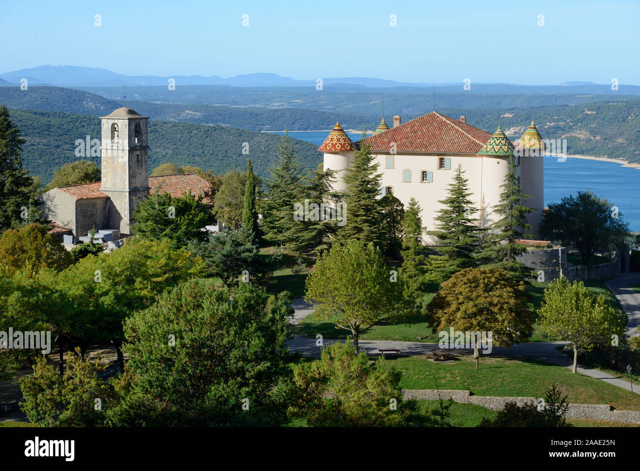 Chateau d'Aiguines & Chiesa di Saint-Jean (c latc) o San Giovanni Aiguines con il lago di Sainte Croix in background Var Provenza Francia Foto Stock