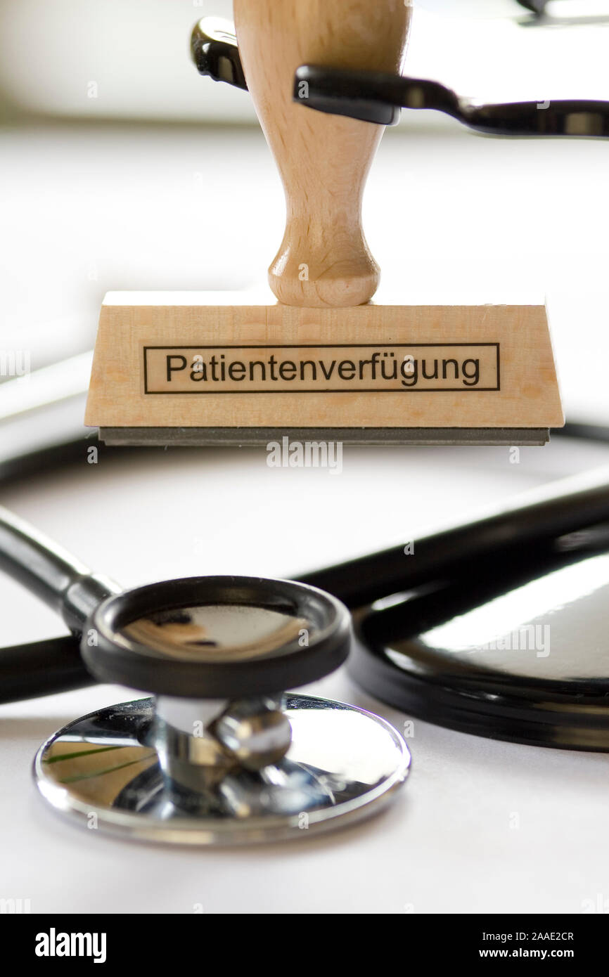 Stempel mit Aufschrift Patientenverfügung hängt un Stempelrondell vor einem Stethoskop Foto Stock