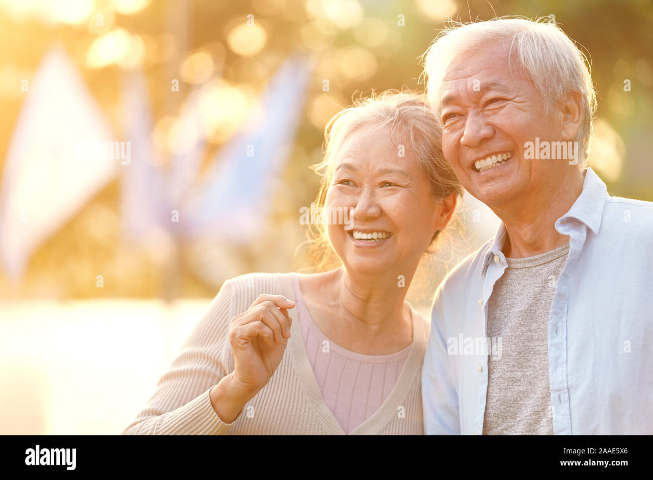 Senior asian giovane godendo di un buon tempo all'aperto nel parco al crepuscolo, felice e sorridente Foto Stock