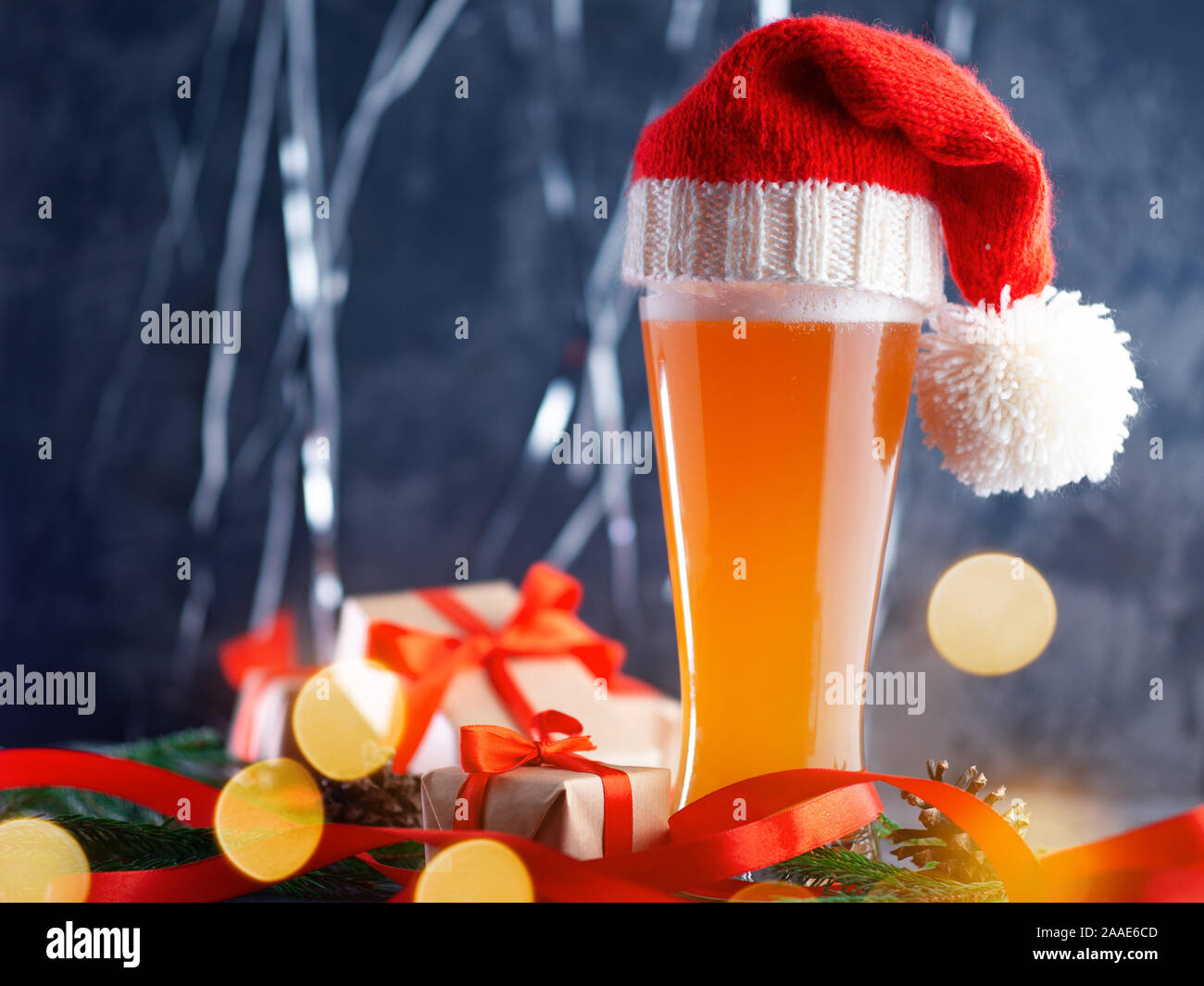 Birra di Natale ale in Santa di Red hat in un bicchiere alto su un sfondo di festa Foto Stock