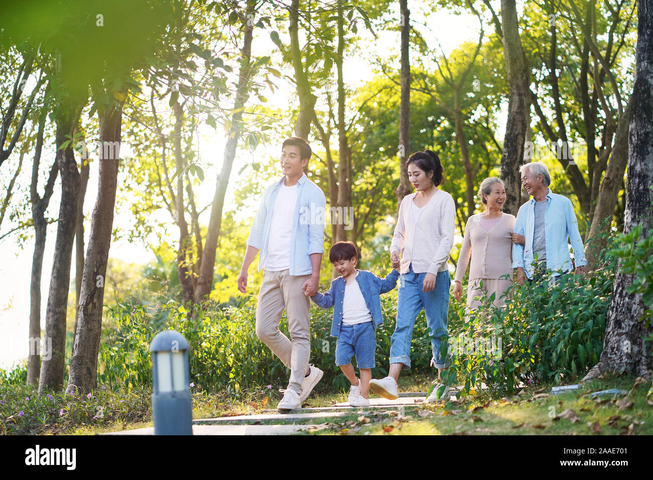 Felice tre generazioni della famiglia asiatica con madre padre figlio NONNA, NONNO rilassanti passeggiate all'aperto nel parco Foto Stock