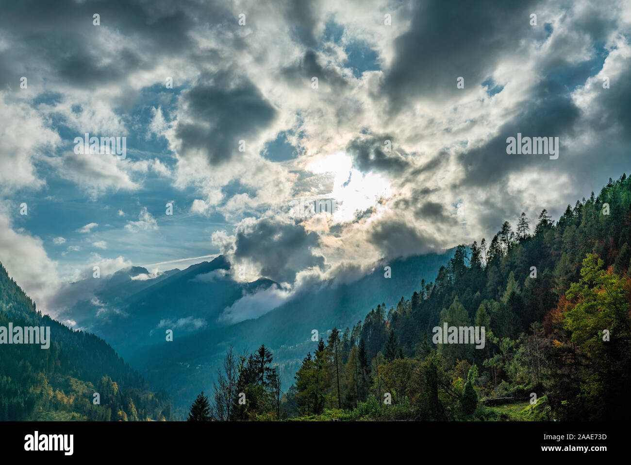 La rottura sole attraverso le nuvole sulla valle del Cordevole delle Dolomiti italiane su una soleggiata giornata autunnale Foto Stock