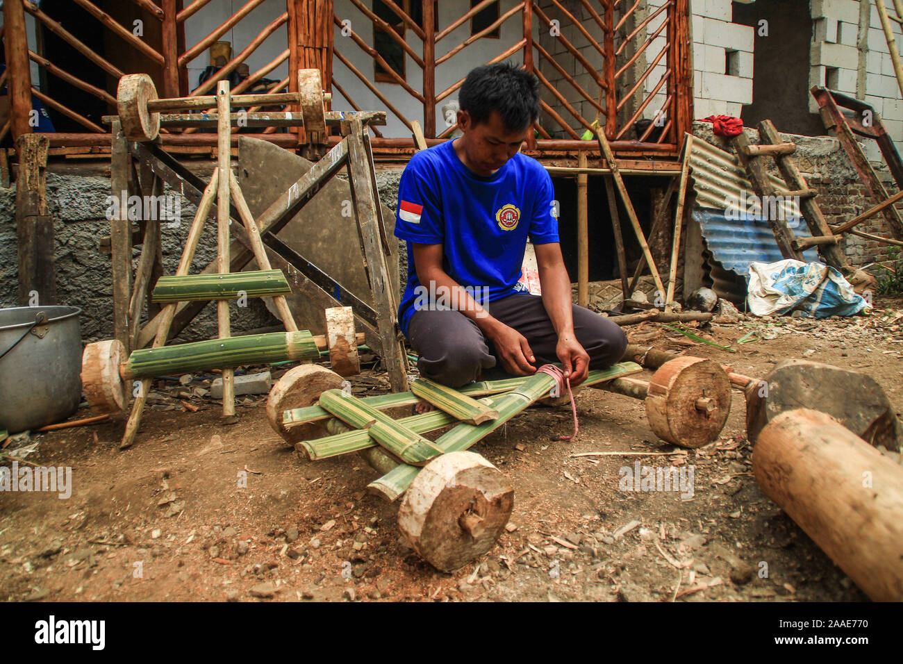 Un residente fissa la sua vettura di bambù in Batu Lonceng Village, Lembang.Il gioco tradizionale è una tradizione ereditaria tenutasi durante la stagione di crescita vacanze come divertimento per gli abitanti di un villaggio. Foto Stock