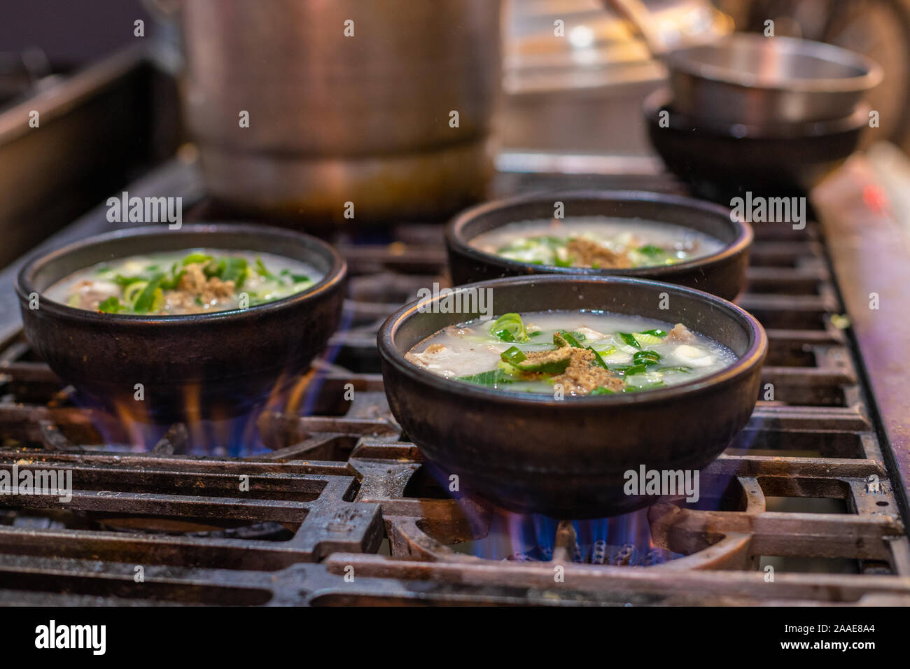 Le tazze con la minestra sul fuoco. Calda zuppa asiatica. Cucina di strada in una tazza sul fuoco. Alta esotica zuppa di fiamma. Foto Stock