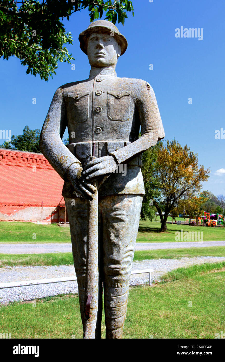 Una statua in cemento e pietra di un soldato Boy della prima guerra mondiale si trova all'attenzione di un parco sulla Main Street a Carney, Oklahoma. Foto Stock