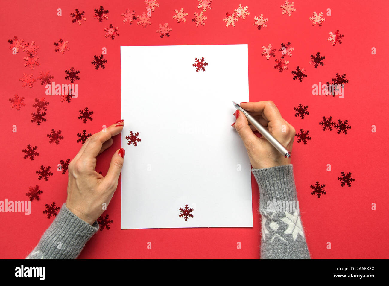 La donna gli obiettivi di scrittura, checklist, piani e sogni. Felice Anno Nuovo. La lista dei desideri per Natale. Elenco impegni per l'anno 2020 su rosso Holiday decor. Spese regalo Foto Stock