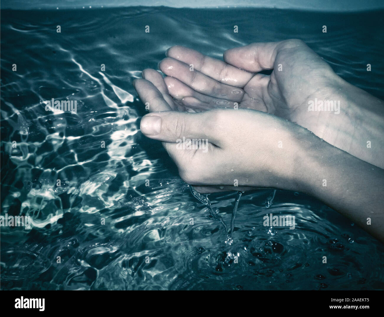 Mani in acqua al buio Foto Stock