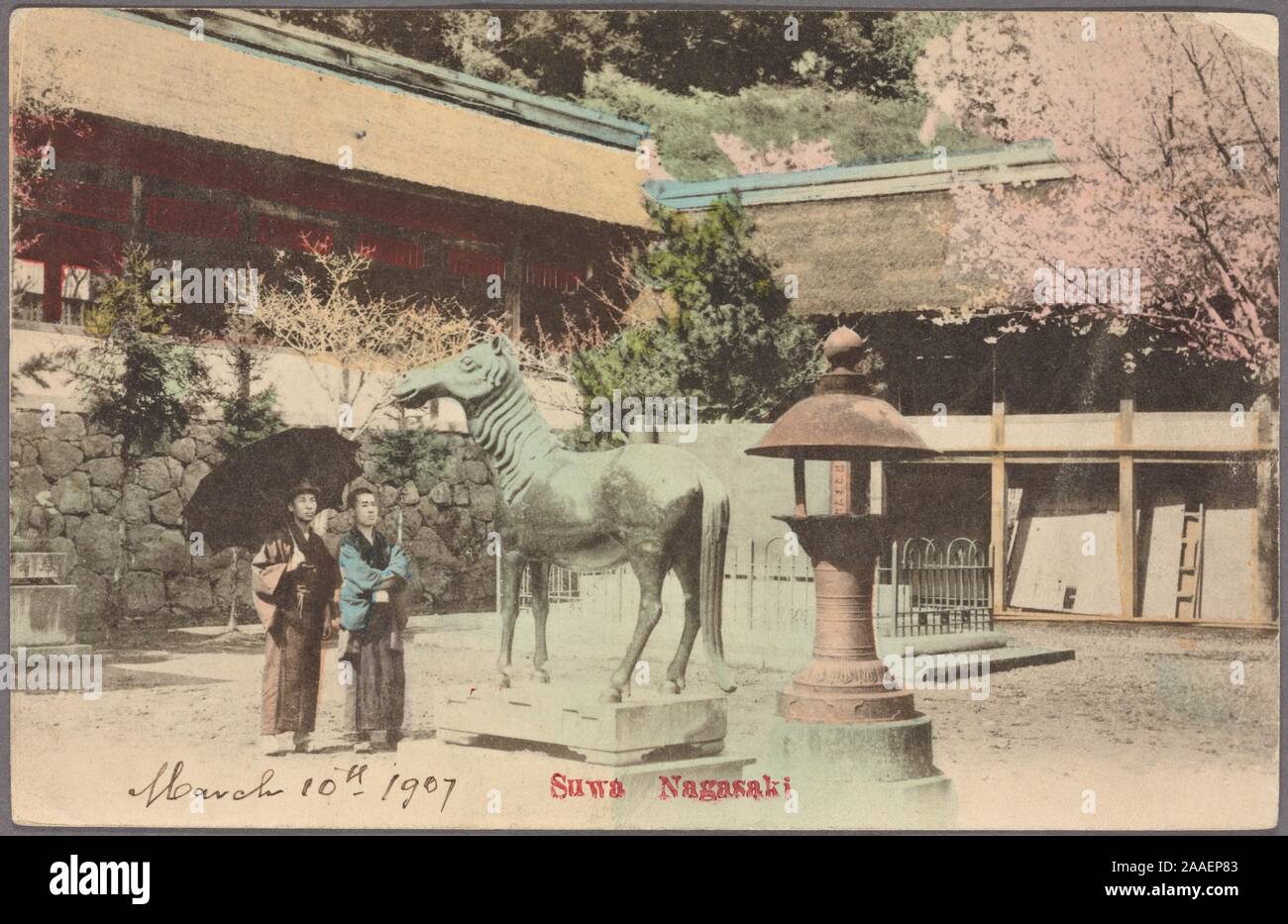 Cartolina illustrata di due locali in abbigliamento tradizionale, uno tenendo un ombrellone, in piedi nel cortile del Santuario di Suwa guardando una statua equestre, di Nagasaki, Giappone, 1907. Dalla Biblioteca Pubblica di New York. () Foto Stock