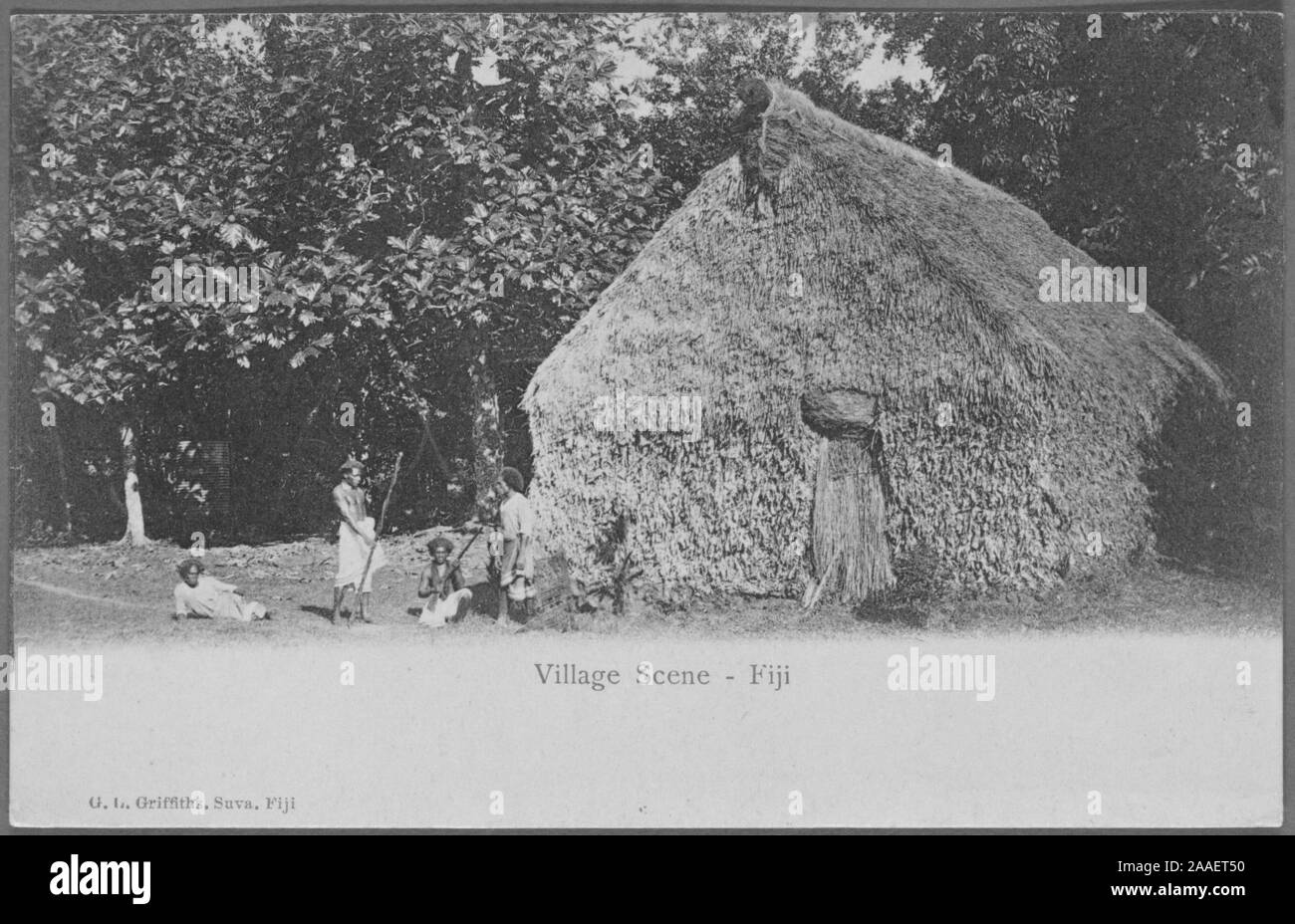 Cartolina inciso di un gruppo locale di uomini di fronte a una capanna con il tetto di paglia in un villaggio nelle isole Figi, pubblicato da G. L, 1905. Griffiths. Dalla Biblioteca Pubblica di New York. () Foto Stock