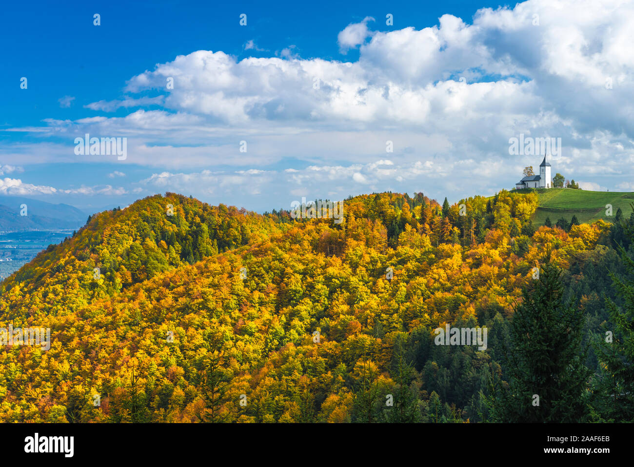 Chiesa di St Primoz con la caduta delle foglie il colore sopra il villaggio di Jamnik, Slovenia, l'Europa. Foto Stock