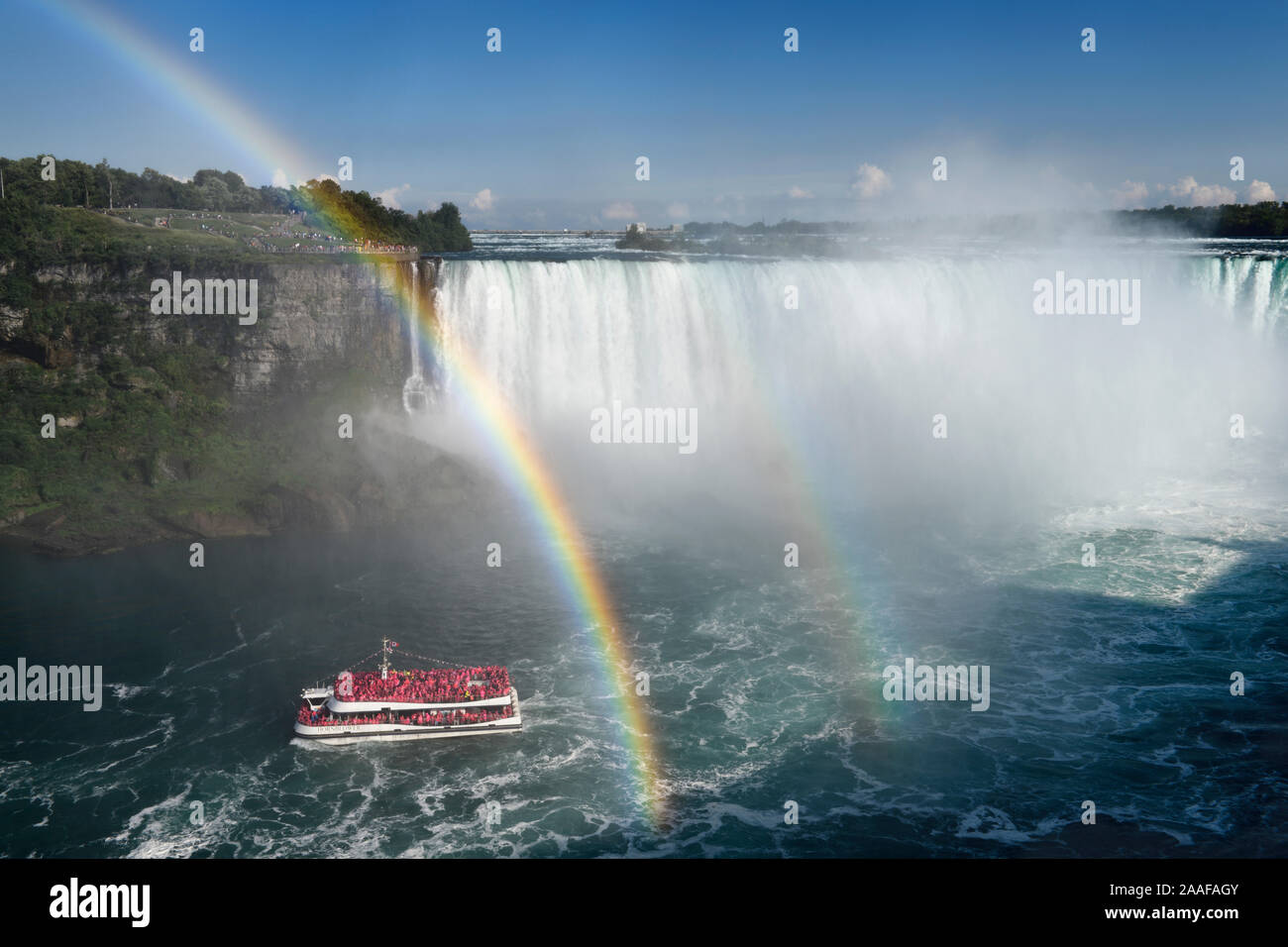 Noi spettatori al punto Tarrapin con doppio arcobaleno che termina su Hornblower tour in barca a Horseshoe Falls a Niagara Falls Ontario Canada Foto Stock