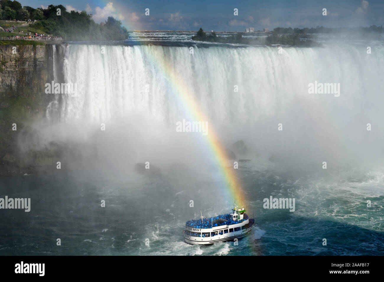 Noi spettatori a doppio arcobaleno che termina oltre la Domestica della Foschia tour in barca a Horseshoe Falls a Niagara Falls Ontario Canada Foto Stock