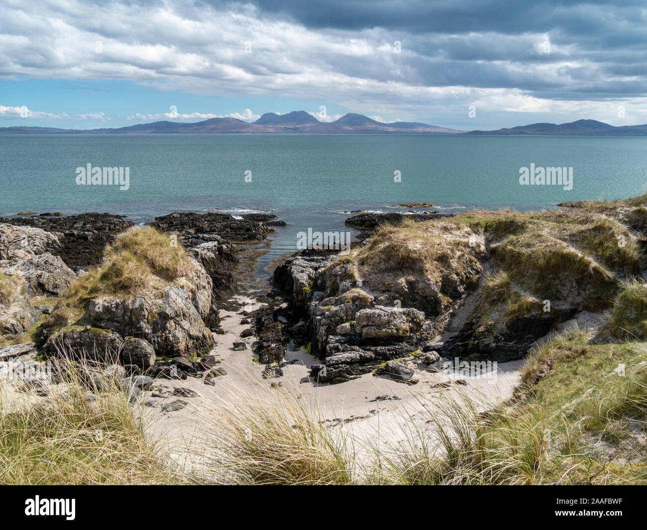 Una vista in lontananza l'Isle of Jura con le pappe del Giura all'orizzonte come si vede dall'Isola di Colonsay, Scotland, Regno Unito Foto Stock