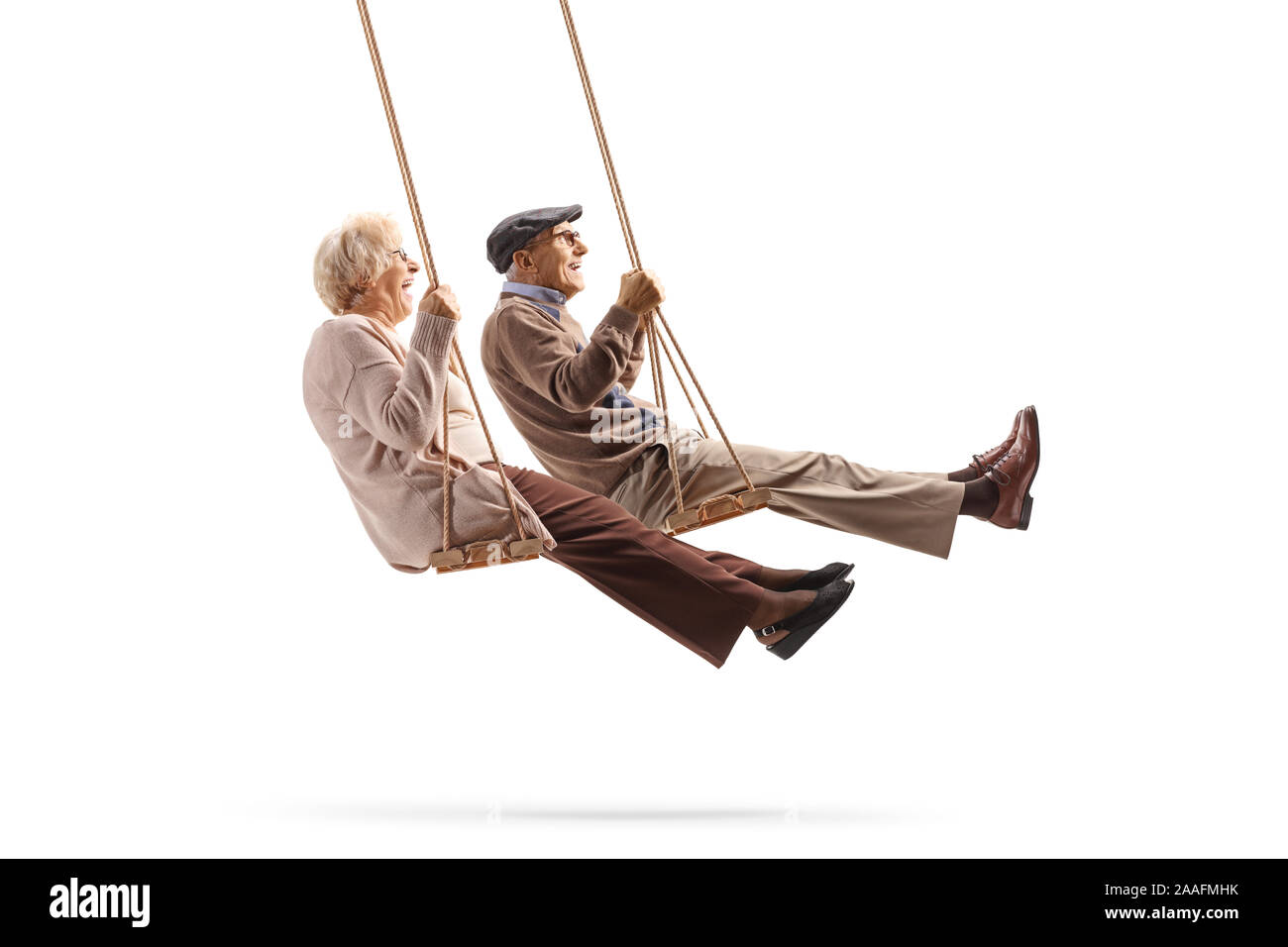 Lunghezza piena ripresa di profilo di un uomo anziano e donna basculante in altalene in legno isolato su sfondo bianco Foto Stock
