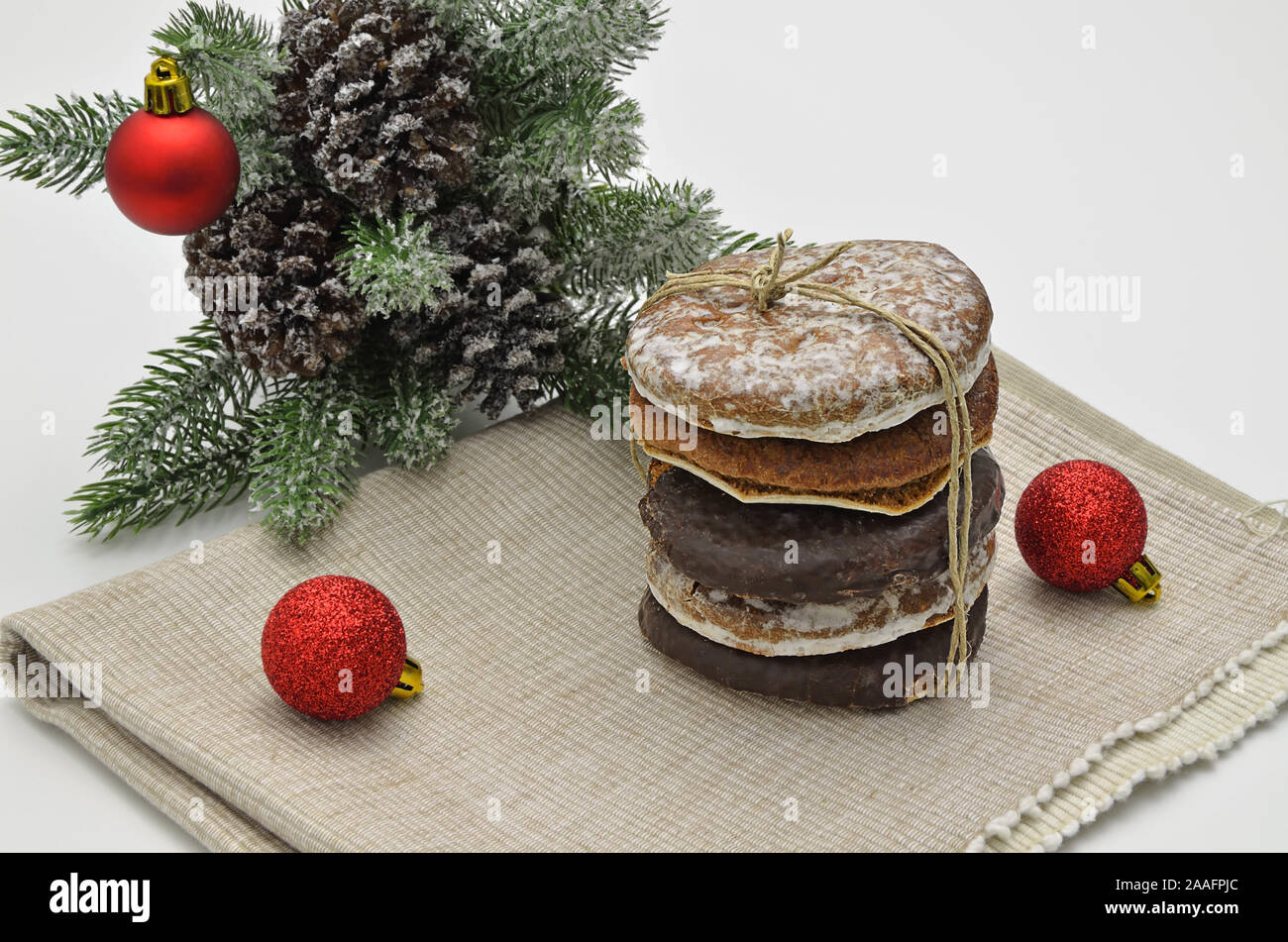 Pila di gingerbread su tela con abete rosso e palla di Natale ornamento, close up su sfondo bianco Foto Stock