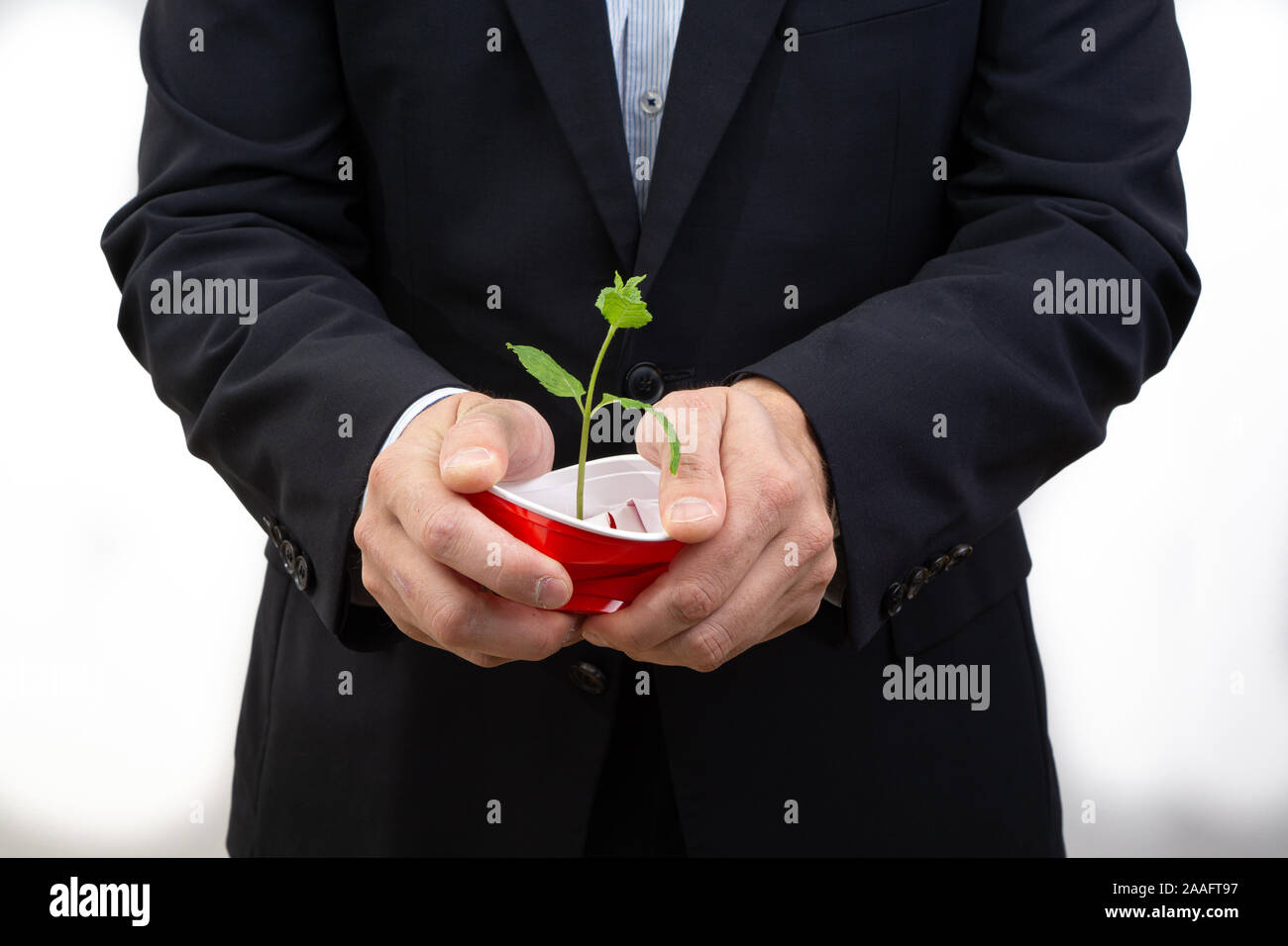 Responsabilità sociale - business man in crash un bicchiere di plastica. evitare di plastica - dire di sì a merci sostenibile per salvare il pianeta. Foto Stock