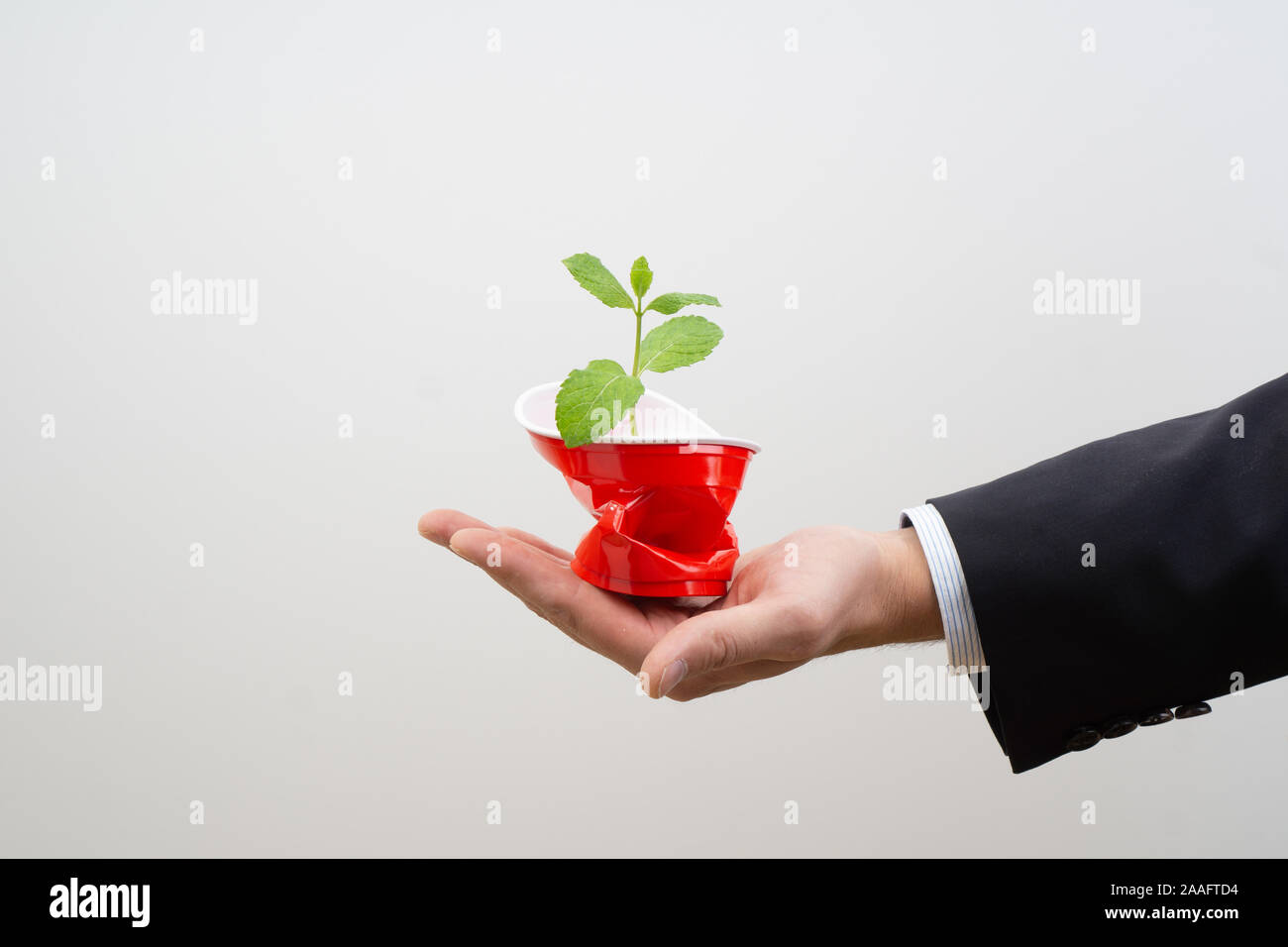 Responsabilità sociale - business man in crash un bicchiere di plastica. evitare di plastica - dire di sì a merci sostenibile per salvare il pianeta. Foto Stock