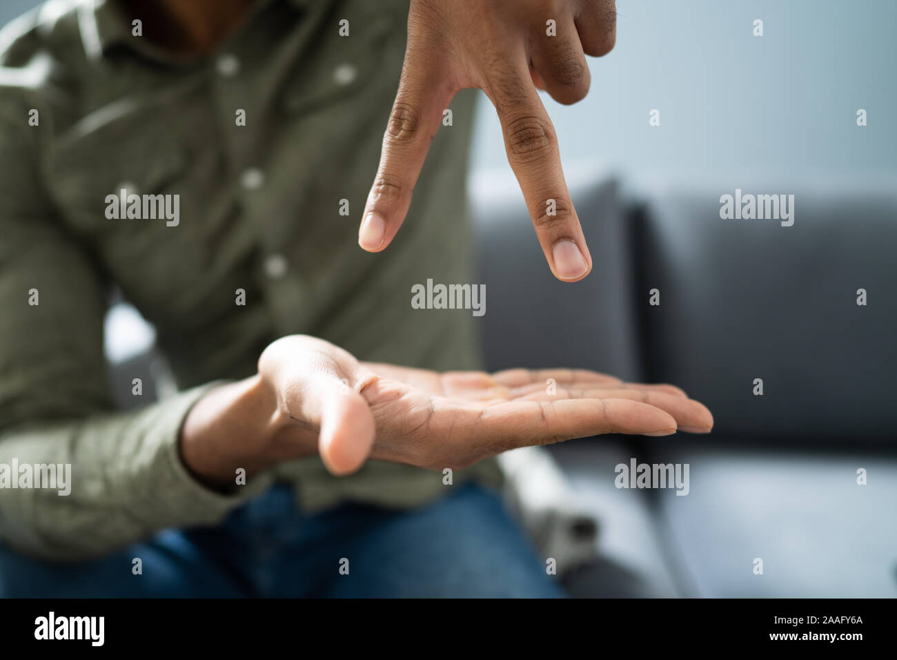 Uomo che utilizza il linguaggio dei segni per comunicare a casa Foto Stock