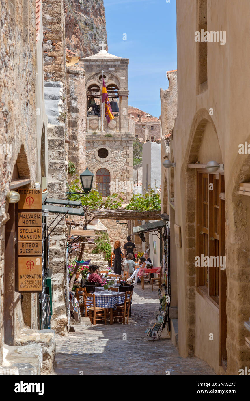 Zona pedonale di Momenvasia, Grecia. Stretto sentiero conduce attraverso i ristoranti e i negozi con turisti che si godono l'atmosfera. Foto Stock