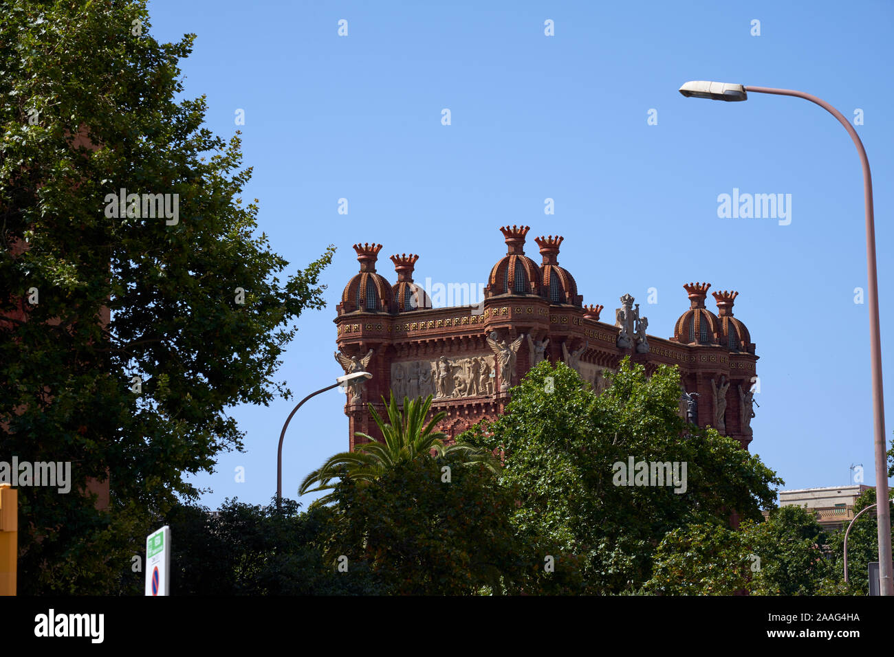 L'Arco di Trionfo appare dietro gli alberi di Barcellona Foto Stock