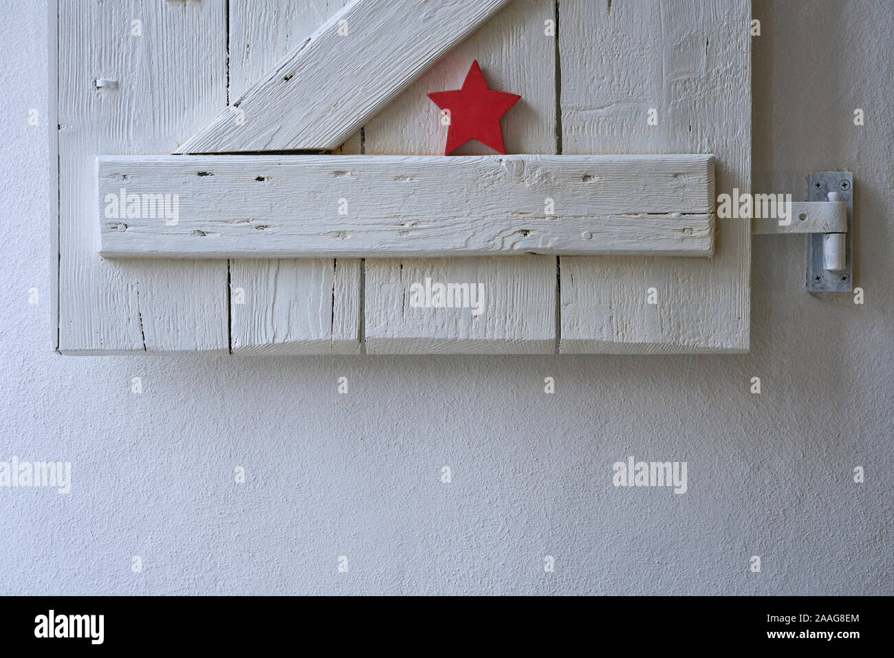 Rossa stella di Natale decorata graziosamente in un bianco shabby otturatore in legno stile scandinavo, spazio di copia Foto Stock