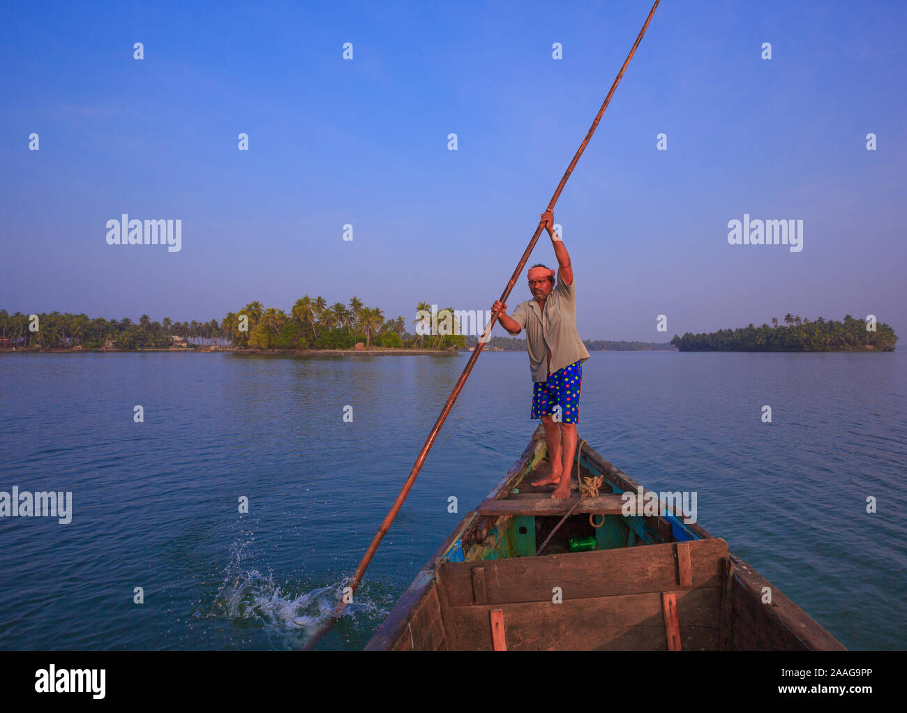 Un barcaiolo spinge la sua barca con un remo di bambù in la serena Suvarna fiume (Udupi, Karnataka, India) Foto Stock