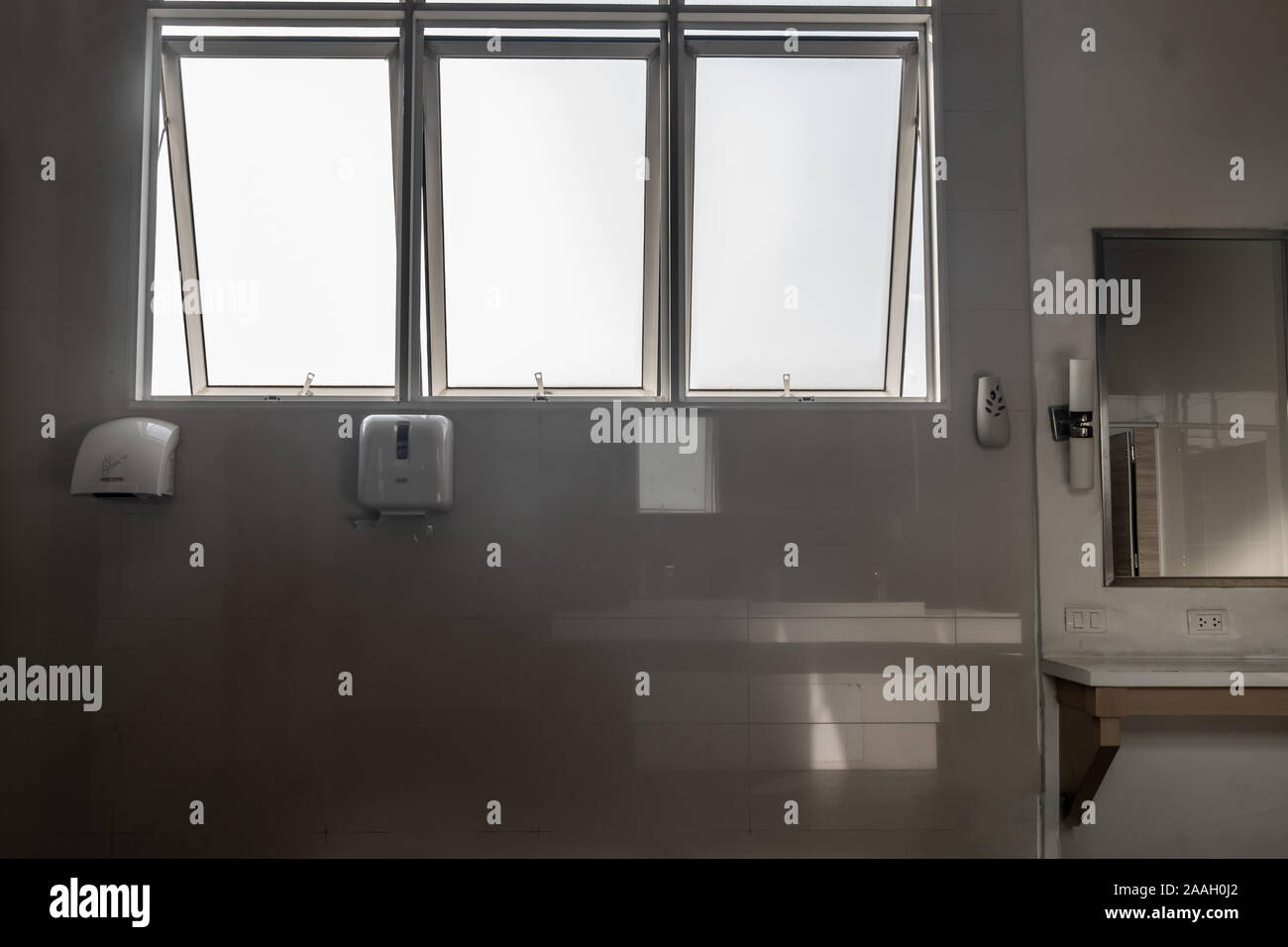 Bianco luce bagno interno con finestra e prive di telaio abbinato a specchio visualizzazione e apparecchiature con luce naturale. Foto Stock