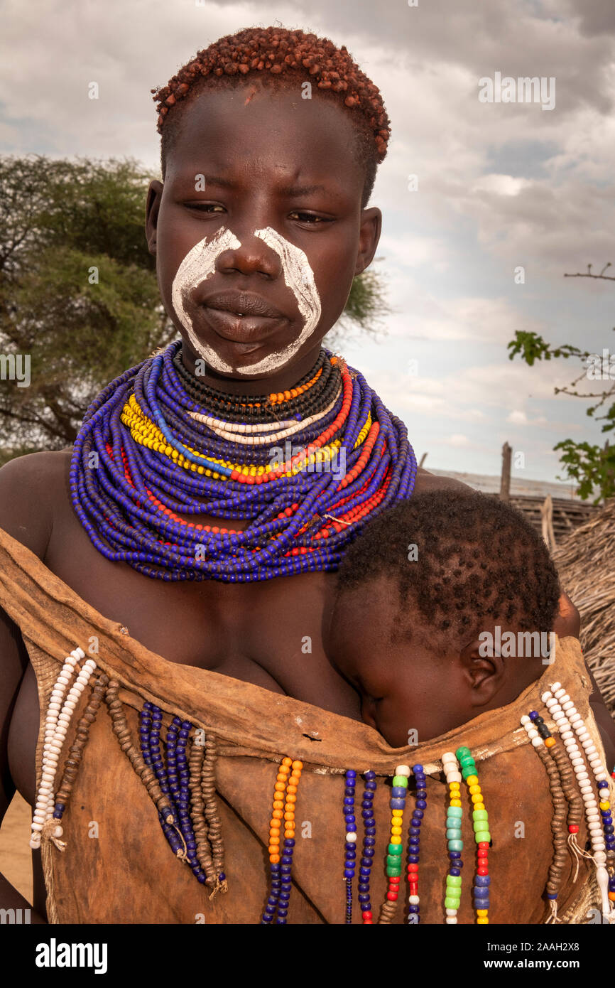 Etiopia, Sud Omo, Kolcho village, tradizionalmente condita e decorate Karo donna tribale con bambino Foto Stock