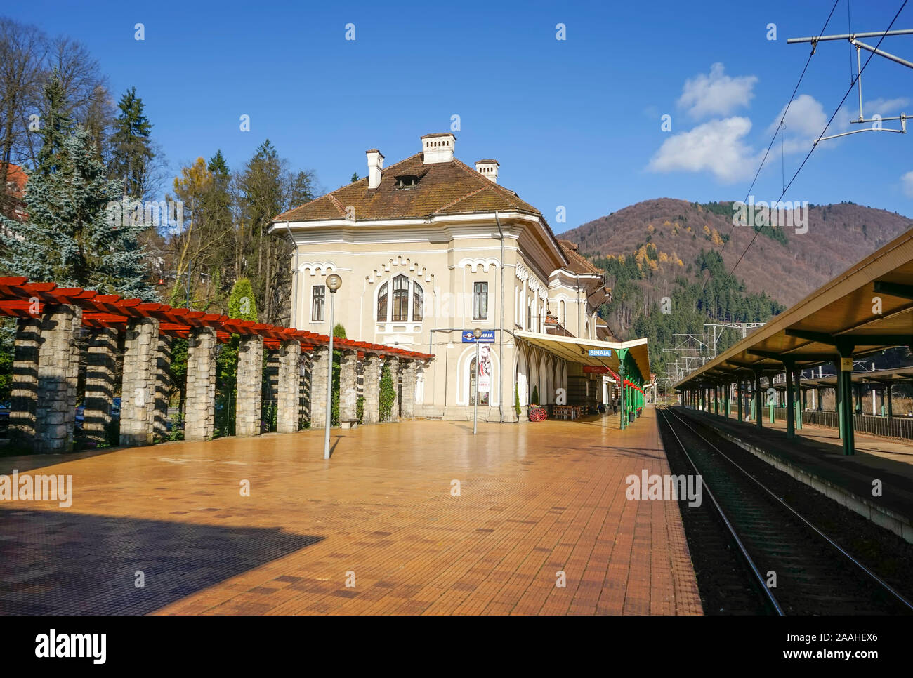 Lo storico edificio della stazione ferroviaria nella città di Sinaia , Romania , con vuoto ferrovie e linee ferroviarie che attraversano le montagne dei Carpazi Foto Stock