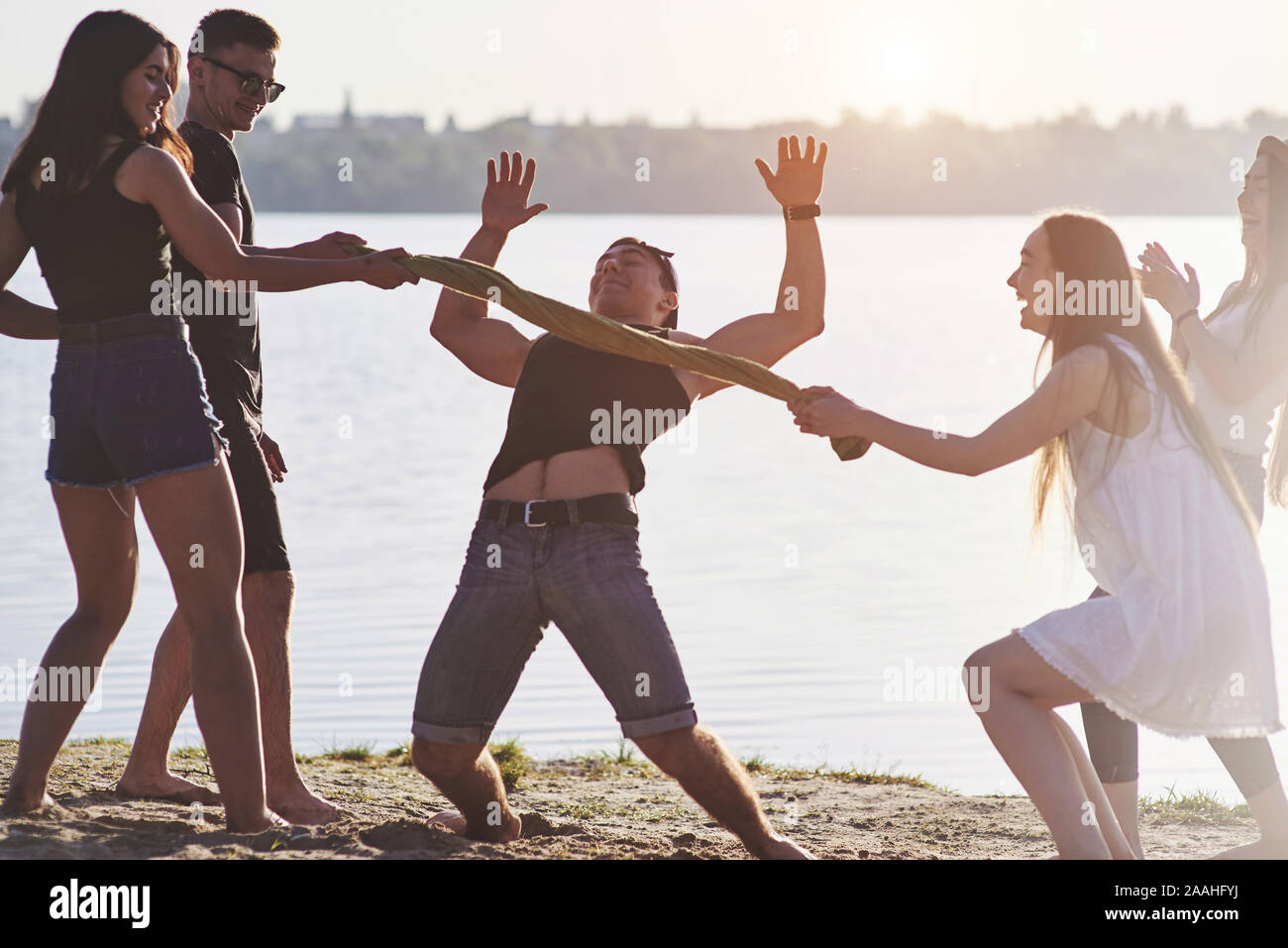 Happy amici divertirsi sulla spiaggia - Giovani giocando in aria aperta acqua su vacanze estive Foto Stock
