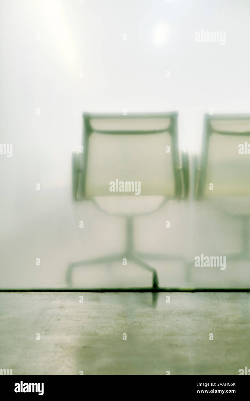 Sedie vuote dietro un vetro parete office partizione - Sala di attesa - ufficio vuoto lo spazio minimo - ufficio di vetro con posti a sedere - sedi vuote sfondo Foto Stock
