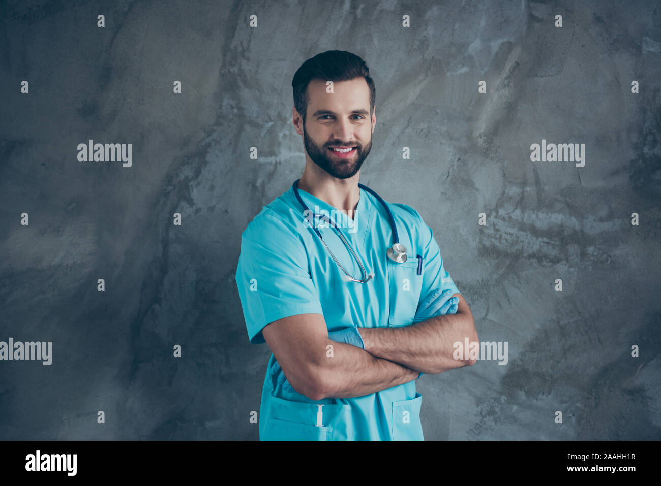 Girato la foto del positivo dai capelli marroni allegro toothy trasmissione via IR di uomo intelligente di indossare i guanti con setole grigio isolato di cemento a parete colore di sfondo Foto Stock