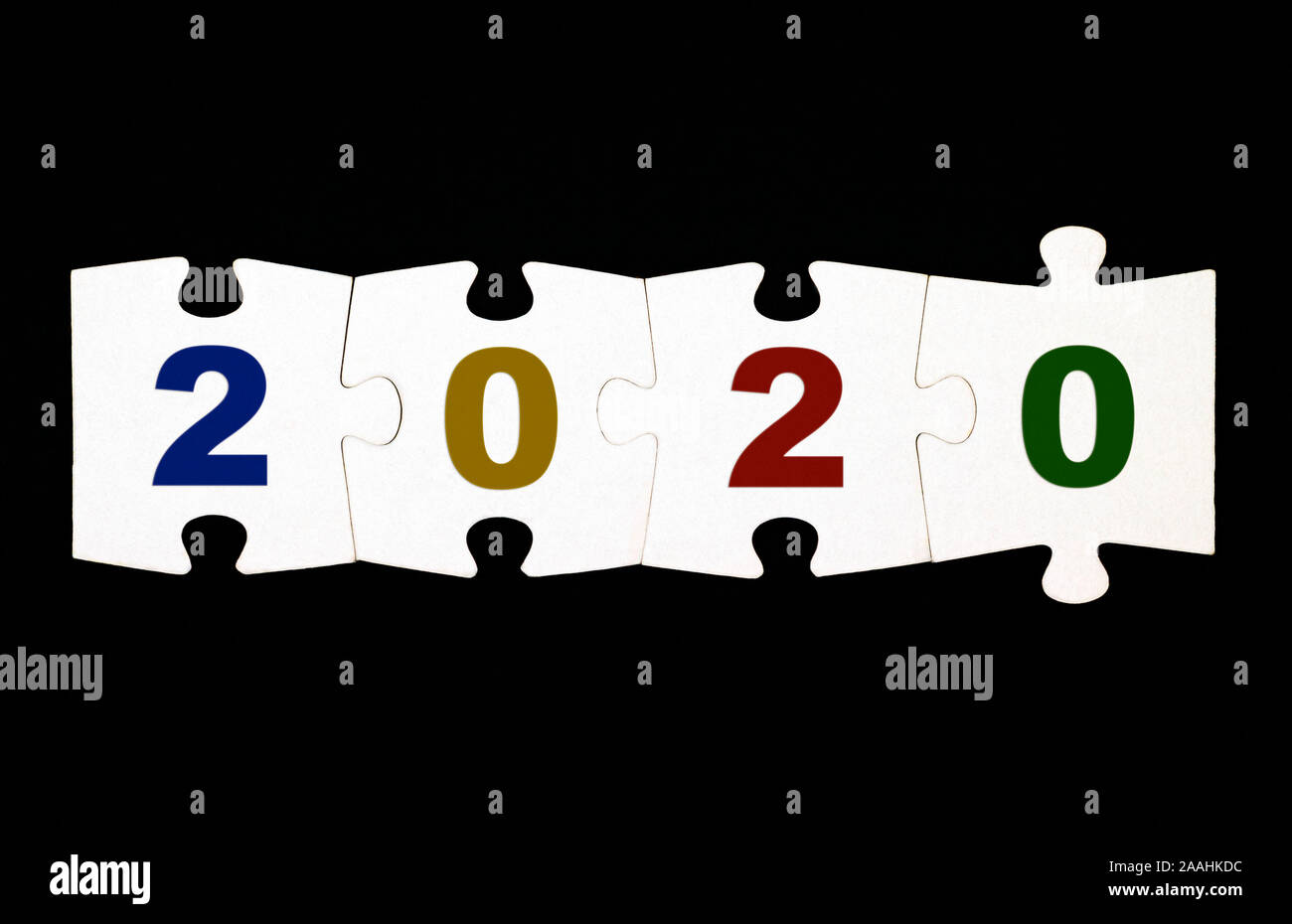 Quattro pezzi di un puzzle con i numeri 2020 sono collegati insieme su sfondo nero Foto Stock