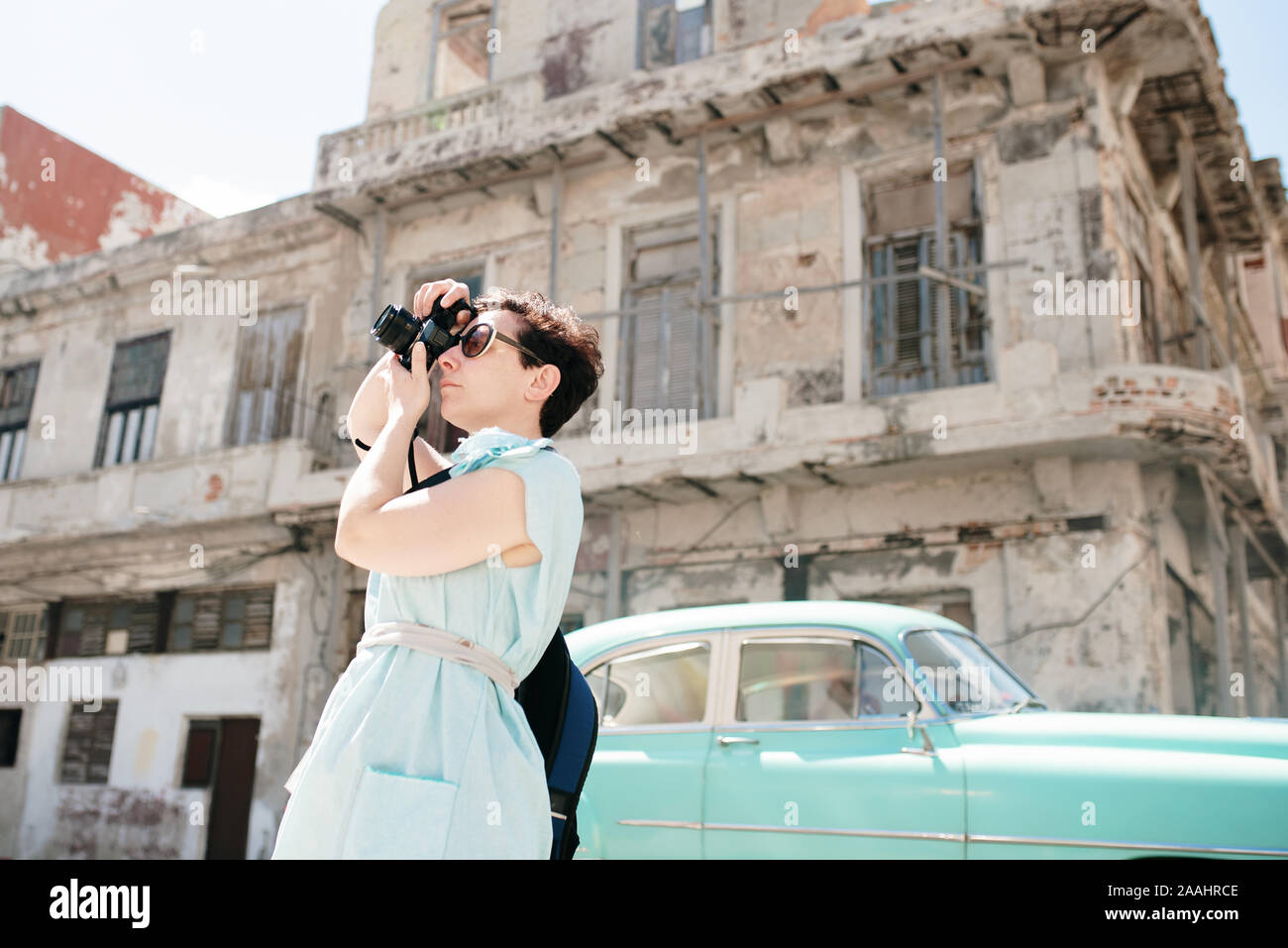 Donna viaggiatore tenendo fotografia in città, Cuba Foto Stock