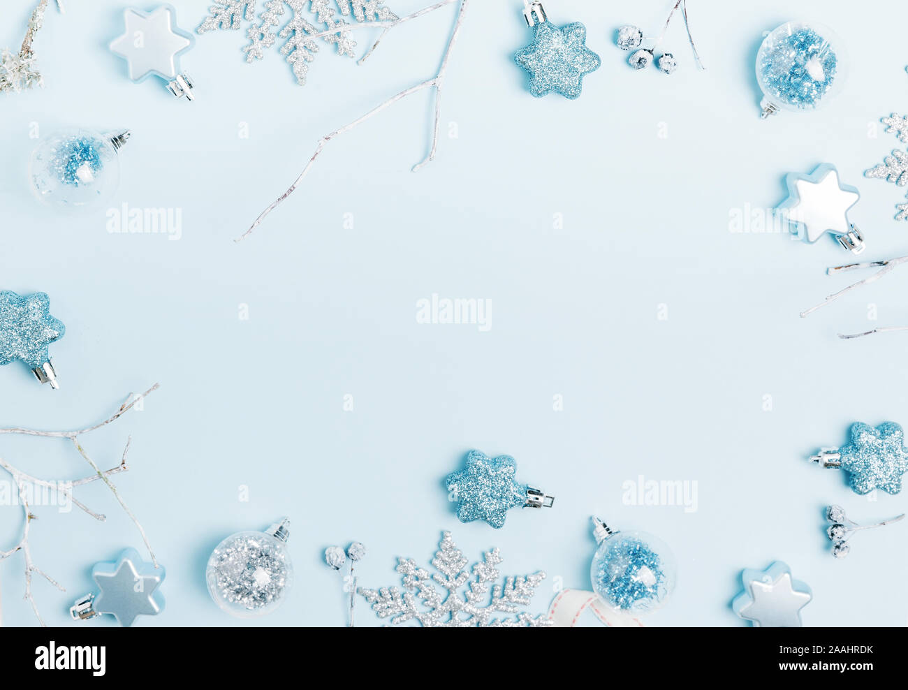 Composizione di natale. Cornice fatta di sfere e fiocchi di neve sul pastello blu sullo sfondo. Foto Stock