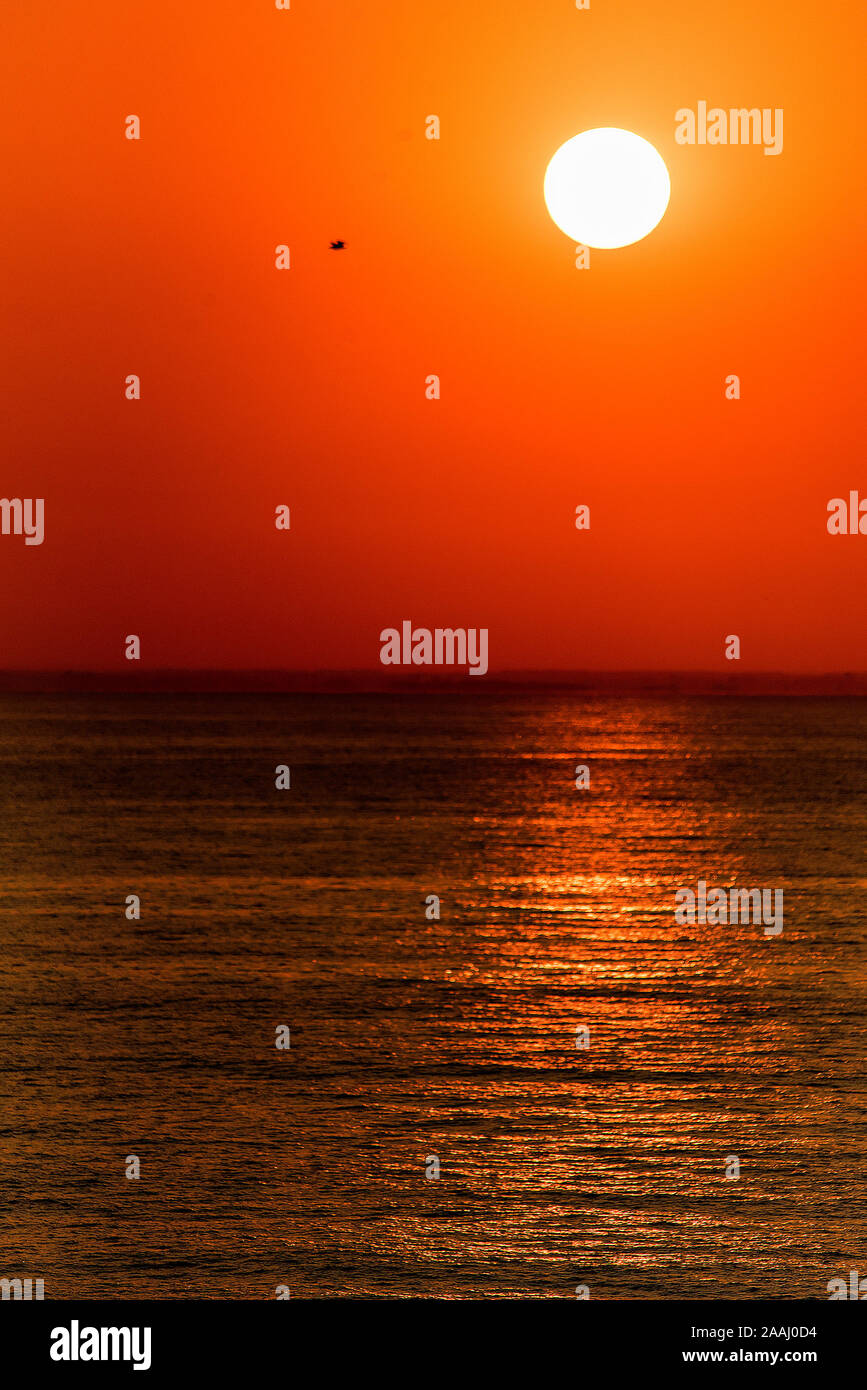 Caldo rosso in stile minimalista tramonto sul mare Foto Stock